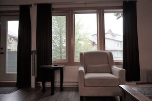 Enjoy a peaceful view from the large window, where a comfortable armchair and small table invite relaxation.