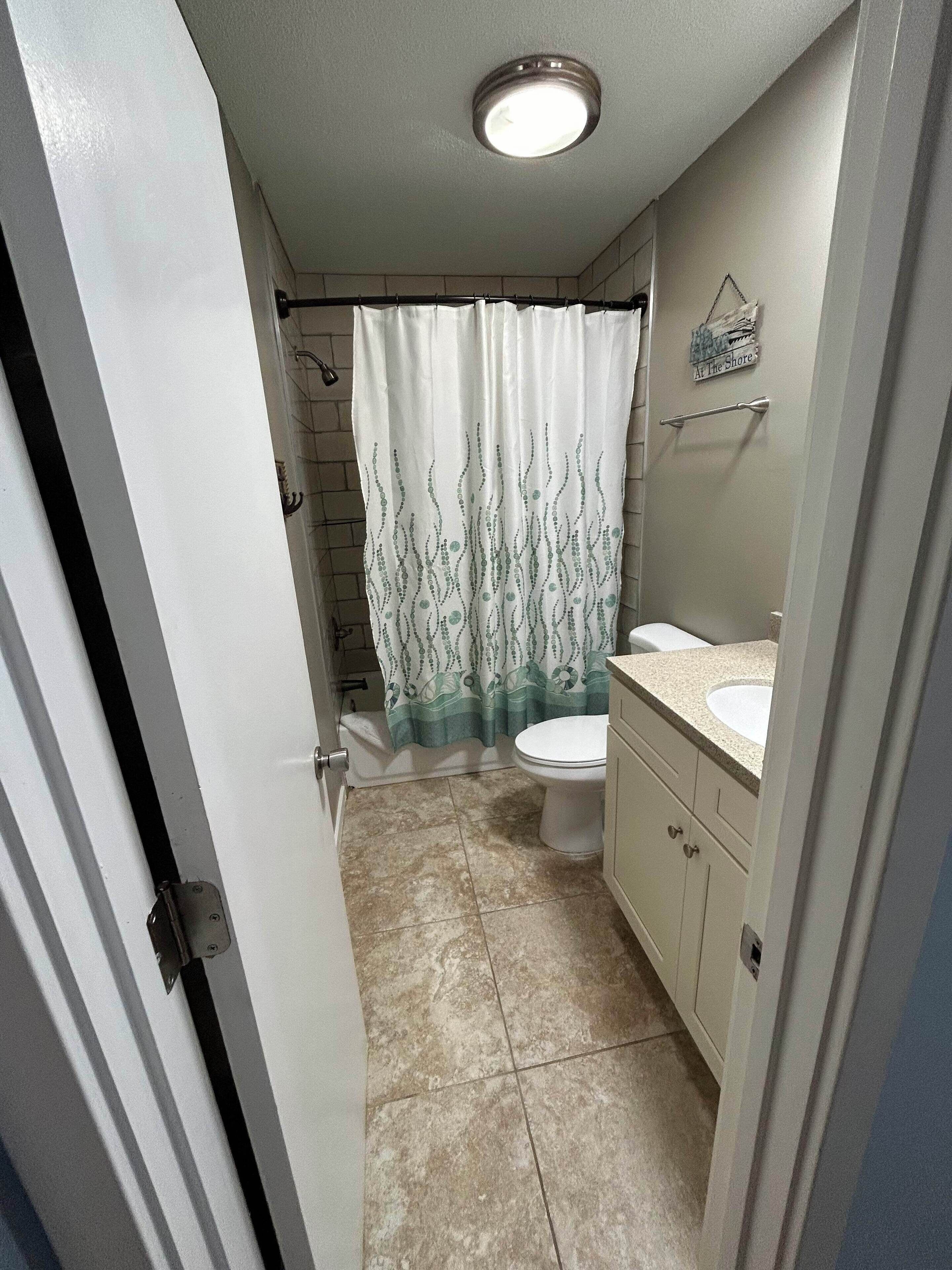 Ein Badezimmer mit Toilette, Waschbecken und Duschvorhang.