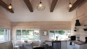 Un intérieur de chalet chaleureux comprenant un coin repas, une cuisine et un espace salon.