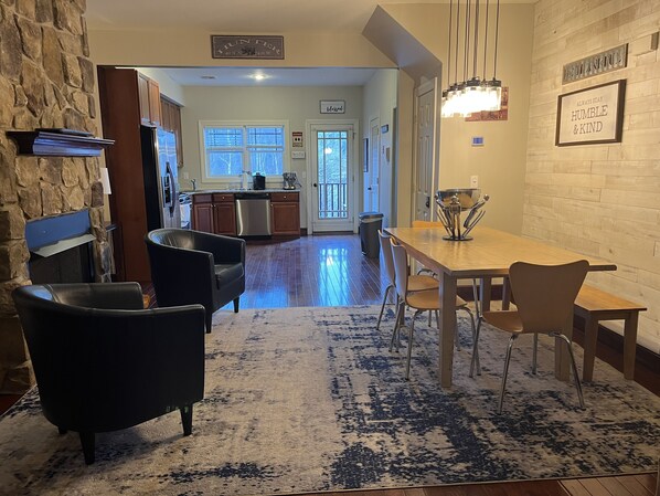 Cozy living area with a dining table, sofa, and armchairs, perfect for relaxing and socializing.