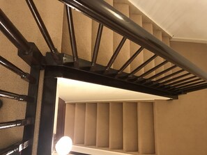 Staircase features a sleek handrail and textured wall paneling.