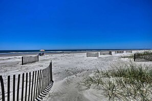 A sandy beach with wooden fences and a clear blue sky.