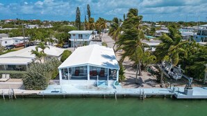 Une propriété située en bord de mer, dotée d’une piscine, d’un espace extérieur aménagé et couvert, et offrant une vue sur l’océan.