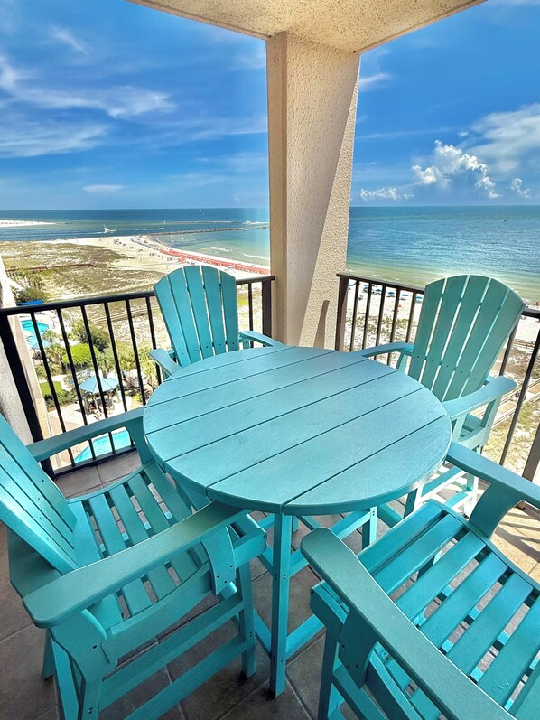 A balcony with a round table and four chairs, overlooking a beach and ocean. - BEST VIEW ON THE BEACH !!!! (Orange Beach)