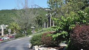 A residential street with houses, a clear sky, and a hilly background. - Next to Silver Dollar City, King Master, 2BR 2BA, Full Size Kitchen, 20ft Patio (Branson)