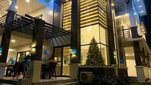 A modern building with a glass facade, a staircase, and a Christmas tree. - Beautiful "Casa Grande" Luxury Villa in Davao City (Davao)
