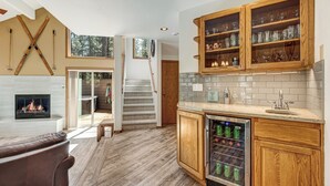 Una cocina moderna con armarios de madera, un refrigerador para vinos empotrado y una chimenea.