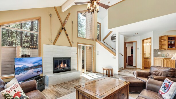 Un salón amplio con chimenea, sofás de cuero y televisor.