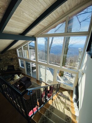 Una habitación amplia con un gran ventanal que ofrece vistas a un paisaje montañoso.