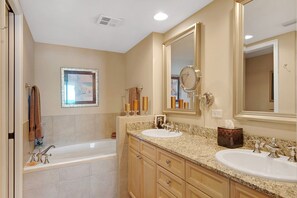 A bathroom with two sinks, a bathtub, and a large mirror. - Gulf front, Portofino paradise, sunset balcony (Pensacola Beach)
