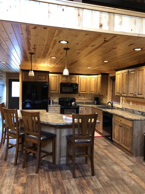 Enjoy meals and social gatherings in this kitchen with a central island, microwave and oven, and ample storage.
