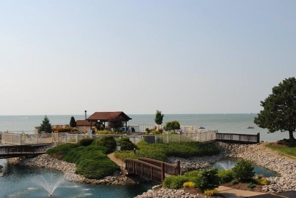 Un complejo turístico frente al mar con piscina, terraza de madera y vistas al océano.