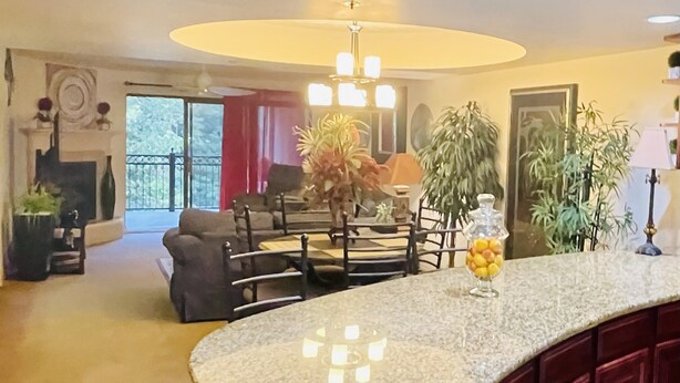 Una sala de estar amplia con chimenea, un comedor con mesa redonda y una cocina con encimera de mármol.