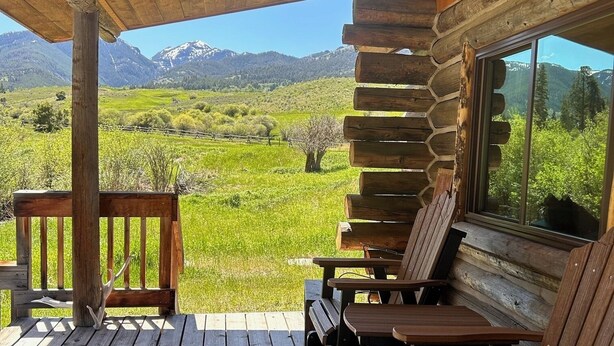 Eine Holzterrasse mit Blick auf eine gebirgige Landschaft.
