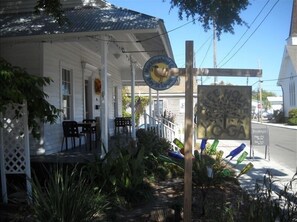 Situated in Bay St. Louis, this charming building features a porch with outdoor seating and lush surroundings.