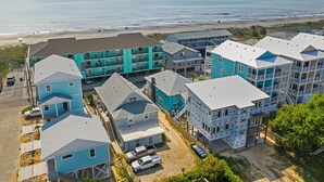 A coastal hotel with multiple buildings, some with balconies, and a view of the beach and ocean. - "Sand Dollar Suites" suite 1: A short stroll from our sandy shores! (Carolina Beach)