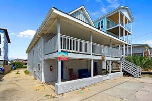 Un immeuble de deux étages doté d’un balcon, d’une enseigne indiquant qu’il propose des logements à la location et d’un escalier menant à l’étage supérieur.