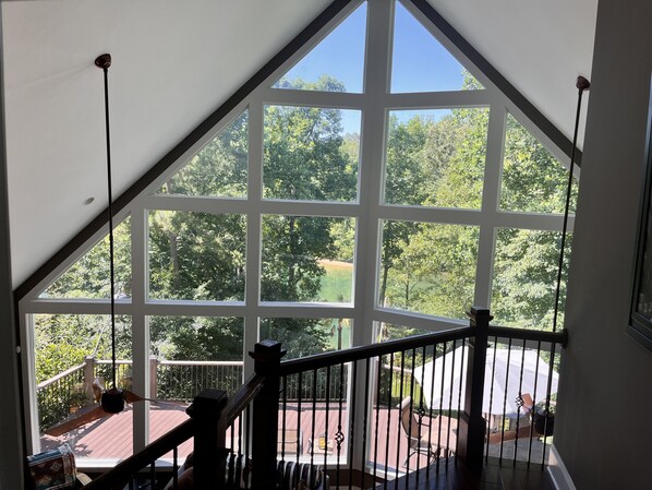 A room with a large window offering a view of a deck and greenery.