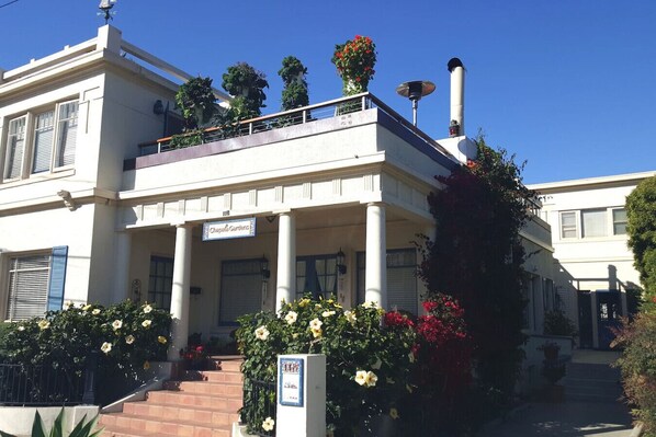 A two-story building with a balcony, a sign reading "Chapelle Gardens," and a chimney. - "LOCATION! LOCATION! West Beach. Beach. New Owner. (Santa Barbara)