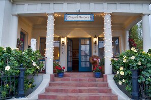 A building entrance with a sign reading "Chapala Gardens," featuring a covered porch with columns, potted plants, and a staircase leading to the door. - "LOCATION! LOCATION! West Beach. Beach. New Owner. (Santa Barbara)