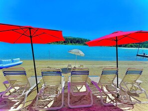 Na praia, espreguiçadeiras, toalhas de praia 