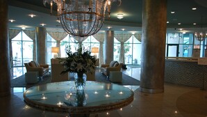 A lobby with a round glass table, two armchairs, a large vase of flowers, and a decorative hanging light fixture. - YaaHooo!!!!! Blue Velvet / Turquoise Place / FABULOUS !!!!!!!!! (Orange Beach)