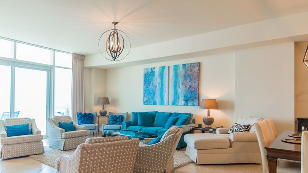 A spacious living room with a large sofa, two armchairs, a coffee table, and a dining table. There are abstract paintings on the wall and a chandelier hanging from the ceiling. - YaaHooo!!!!! Blue Velvet / Turquoise Place / FABULOUS !!!!!!!!! (Orange Beach)