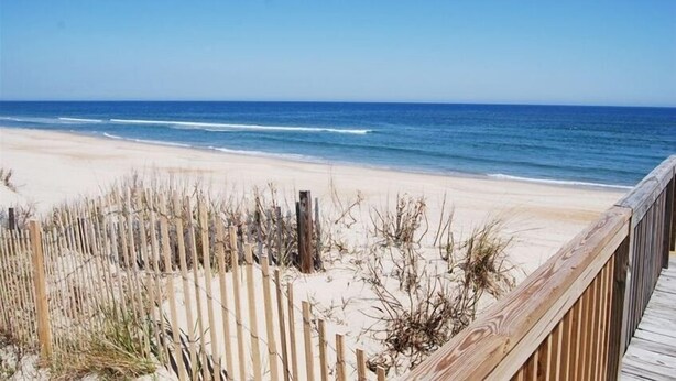 A beach with a wooden boardwalk and a sandy shore. - Beautiful Oceanside Property W/Pool in Great Beach Location! (Corolla)