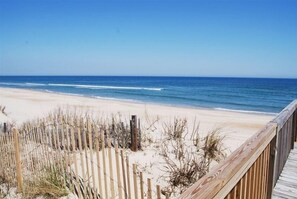 A beach with a wooden boardwalk and a sandy shore. - Beautiful Oceanside Property W/Pool in Great Beach Location! (Corolla)
