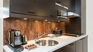 Una cocina moderna con electrodomésticos de acero inoxidable, microondas integrado y cafetera.