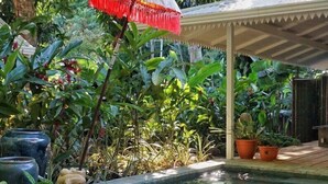 A poolside area with a covered seating area, a wooden table with coconuts, and various potted plants. - 4BR Boutique Jungle Villa • Private Pool • Walkable Manuel Antonio (Manuel Antonio)