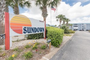 A sign with the word 'SUNDOWN' and a partial view of a building in the background.