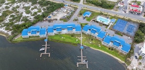 Un hôtel situé sur la côte, composé de plusieurs bâtiments aux toits bleus, doté d’un quai et d’un terrain de basketball.