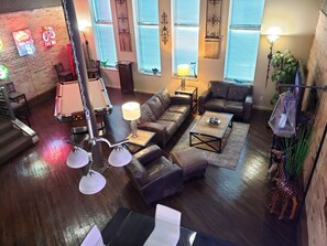 Een gezellige woonkamer met een pooltafel, leren banken en een salontafel.