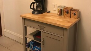 A kitchenette with a coffee maker, pots, and storage boxes. - Cozy Seward Home - Close To Everything (Minneapolis)