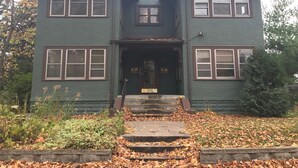 A two-story house with a front porch, a number '2520' on the door, and a small garden area with steps leading to the entrance. - Cozy Seward Home - Close To Everything (Minneapolis)
