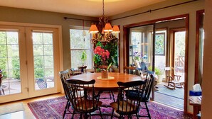 A dining area with a wooden table, black chairs, and a chandelier. - Charming Home quiet neighborhood lovely back yard 5 min from Garden of Gods (Colorado Springs)