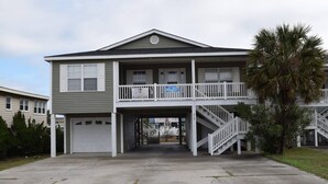 A two-story house with a balcony, a garage, and a staircase leading to the second floor. - Clean Beach House on 2nd row easy access to beach! (Cherry Grove)