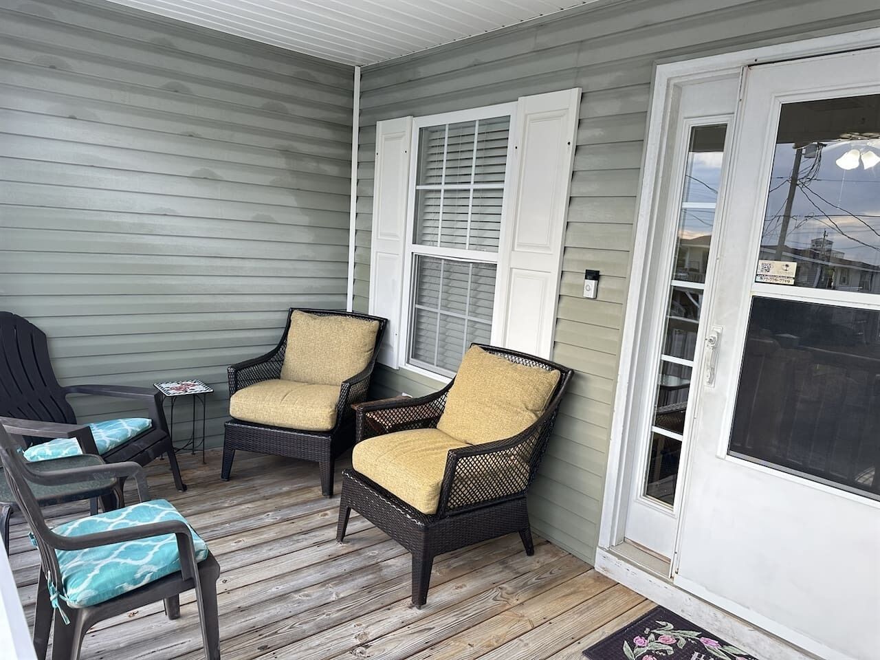 A porch with wicker chairs and a small table.