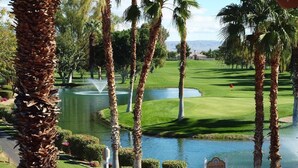 Un parcours de golf agrémenté de palmiers, d’un étang et d’un panneau indiquant « Indian Springs ».