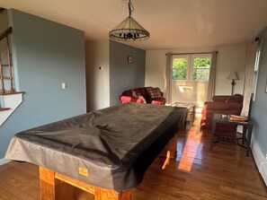 Ein Zimmer mit einem Bett, einem roten Sofa, einem Holztisch und einer Lampe.