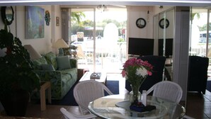 A living area with a sofa, chairs, a glass table, and a TV. -  Spring & summer dates available licensed rental vr #25-0235  NO BOATS (tavernier)