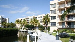 A waterfront hotel with a dock, palm trees, and a pathway. -  Spring & summer dates available licensed rental vr #25-0235  NO BOATS (tavernier)