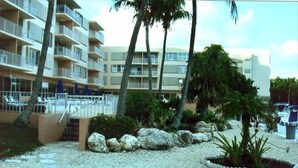 A multi-story hotel with balconies, palm trees, and a gravel pathway. -  Spring & summer dates available licensed rental vr #25-0235  NO BOATS (tavernier)