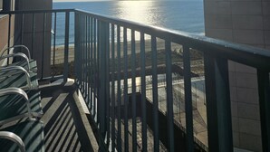 Un balcon avec vue sur la mer, une balustrade et un ciel dégagé.