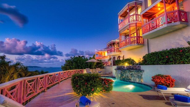 Un hôtel à plusieurs étages, doté de balcons, d’une piscine et offrant une vue sur la mer.