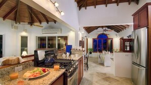 Une cuisine spacieuse dotée de plans de travail en granit, d’une cuisinière à gaz et d’un réfrigérateur.