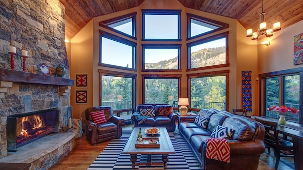 A spacious living room with a fireplace, large windows, and a high ceiling. - Million Dollar Views on Lake Purgatory! Only 1 Mile to Ski Resort! (Durango)