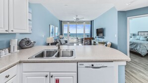 Een moderne keuken met een centraal eiland, een inbouwvaatwasser en uitzicht naar buiten.