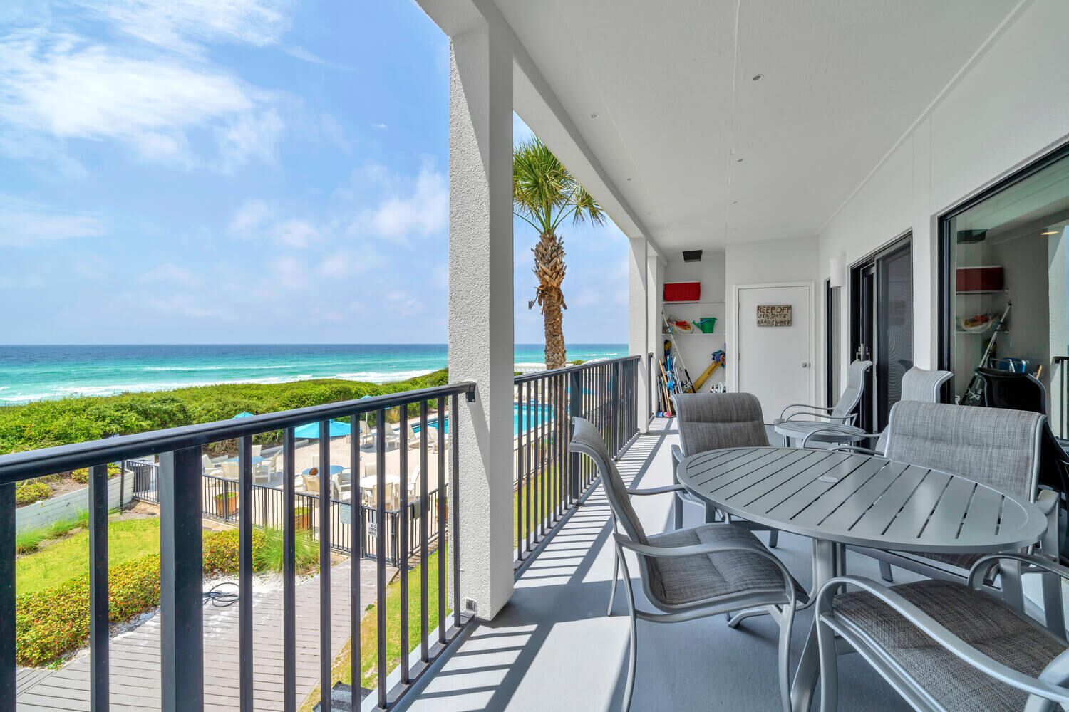 View of balcony with table, four dining checks, two large chairs looking West